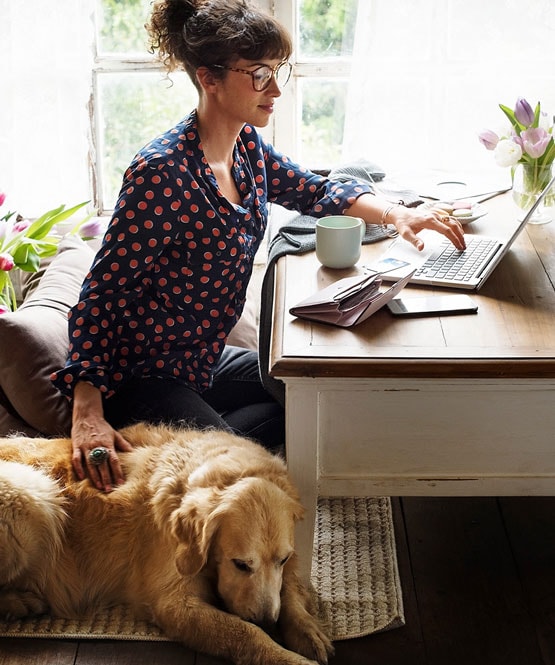 Business owner working from home with a dog nearby